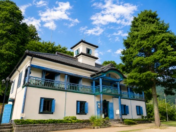 *【明治校舎】青い窓枠が印象的な明治校舎。三代校舎が並ぶ懐かしい里山へ