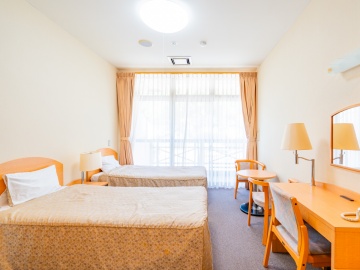 *洋室一例/明るくてシングルベッドが2台並んだお部屋。旅の疲れをベッドでゆっくり癒してください。