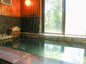 *［貸切風呂一例／浴槽］板状節理の発達した安山岩で造られた鉄平石風呂です