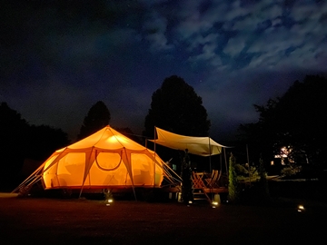 *グランピングテント（夜）／ソーラーライトを灯し、ガーデンテーブルに出て星空観察が楽しめます。